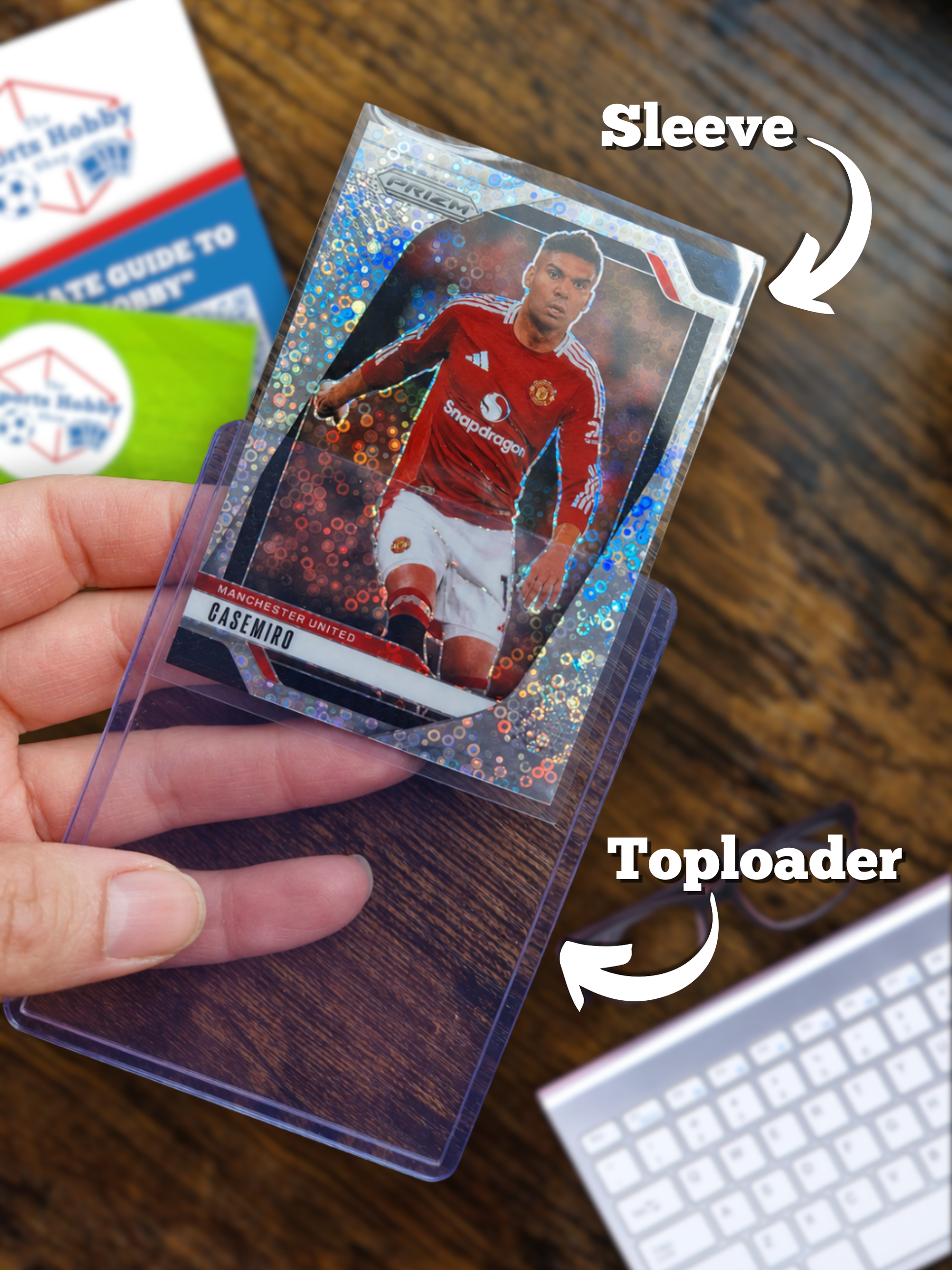 Hand holding a Manchester united sports trading card with a toploader and sleeve.